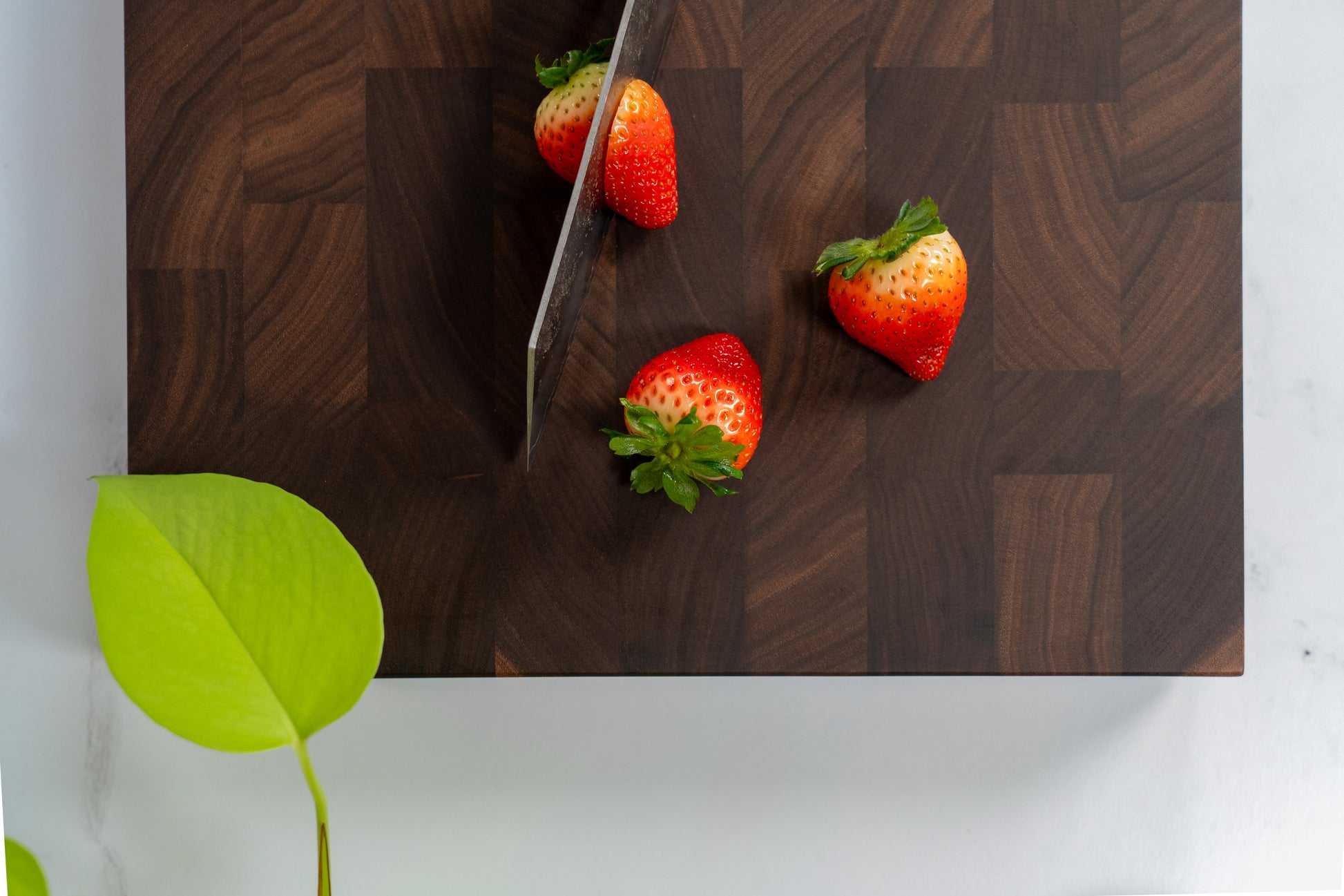 Walnut wood cutting board, square walnut cutting board, fresh cut strawberries, neon pothos
