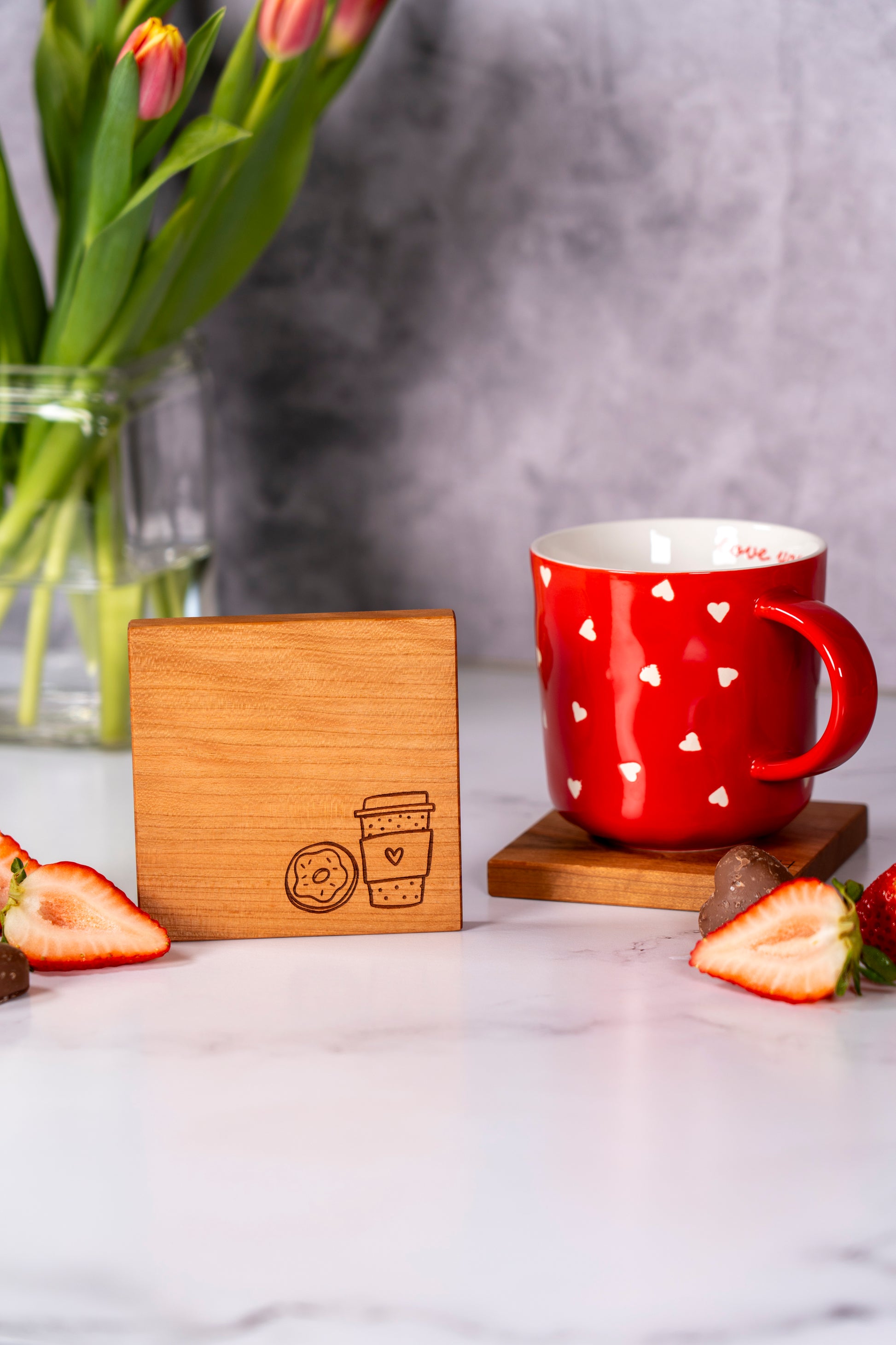Cherry wood coaster set for coffee lover, cute coffee to go and donut engraving for coffee lover, best gift for girlfriend, square 4x4 wooden coasters made by Square Root Studio, USA made coasters set, Heart themed mug sitting on a wooden coaster on the kitchen countertop