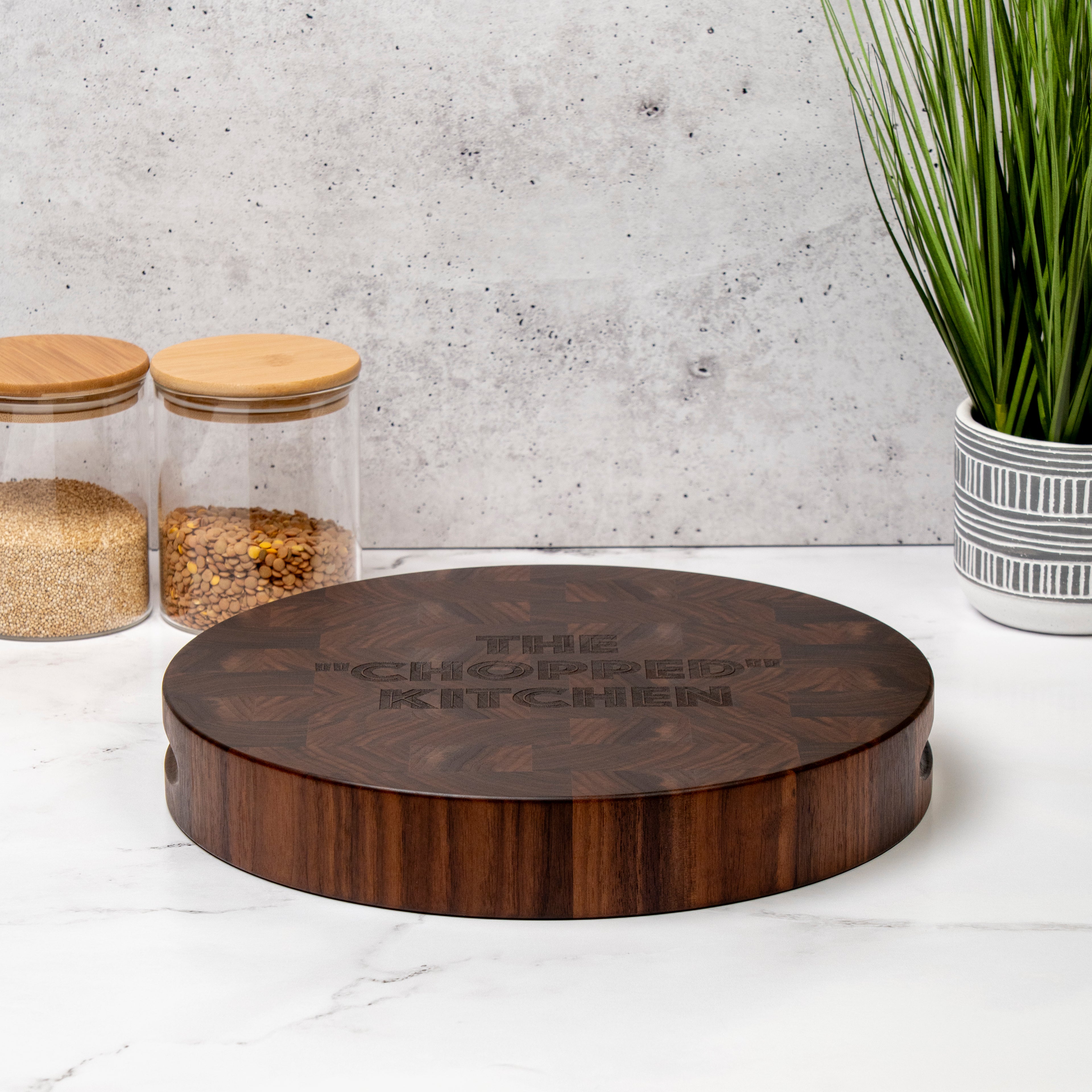 round end-grain cutting board with "the chopped kitchen" message engraved on the top face, custom engraving for the chopped show fans, ideal gift for kitchen enthusiasts, handmade butcher block 100% made in USA by Square Root Studio